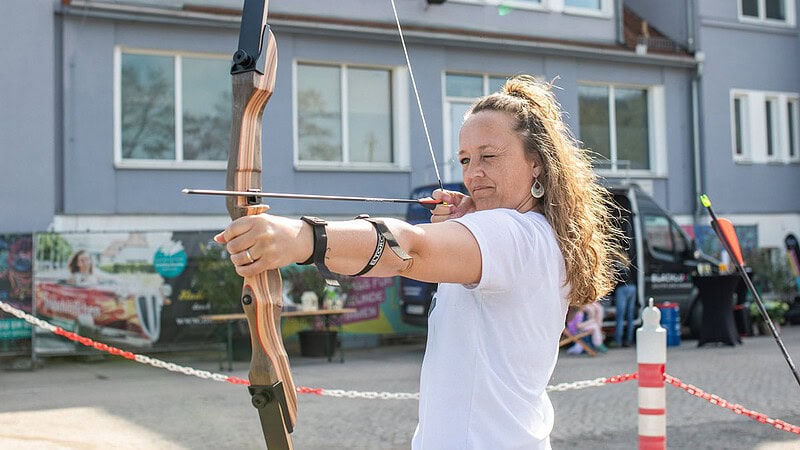 Frau spannt Bogen