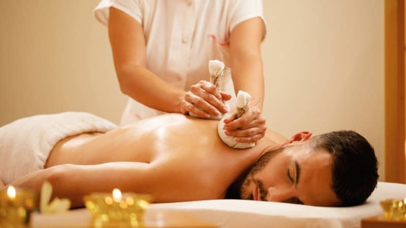 Ein Mann bekommt eine entspannende ayurvedische Rückenmassage.