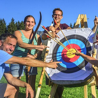 Gruppe von Männer und Frauen vor einer Zielscheibe beim Bogenschießen in Dresden
