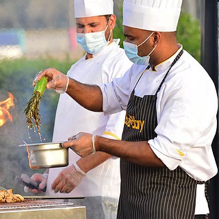 Zwei Köche grillen Gemüse zusammen