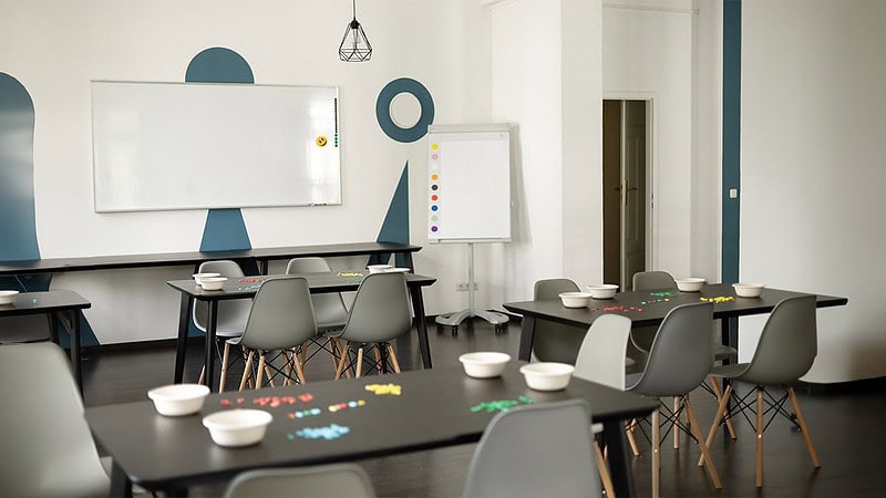 Ein Spielraum mit Tischen und Stühlen für unterschiedliche Wissens- und Geschicklichkeitsspiele bei Hall of Game in Dresden.