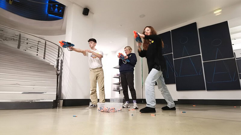 Drei Personen spielen eines der Spiele mit Nerfpistolen bei Hall of Game in Dresden.