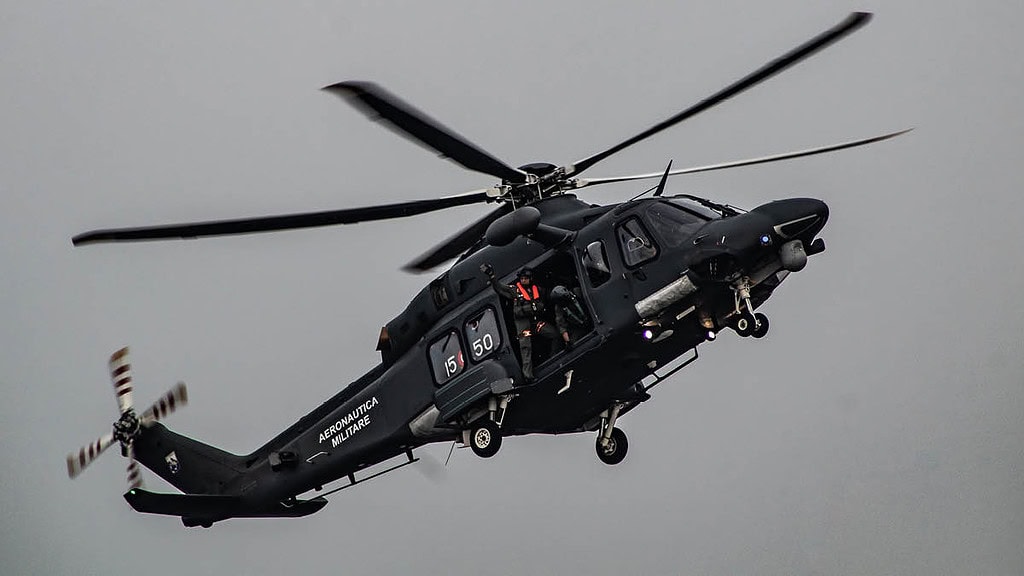 Menschen sitzen in offener Tür eines Helikopters in der Luft - Actionflug im Hubschrauber