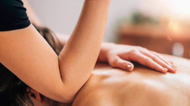 Eine Person wird sanft mit einem Ellenbogen bei einer Lomi Lomi Massage massiert.