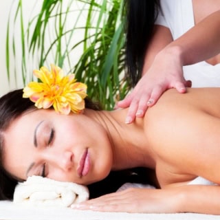 Eine Frau genießt eine entspannende Lomi Lomi Massage.