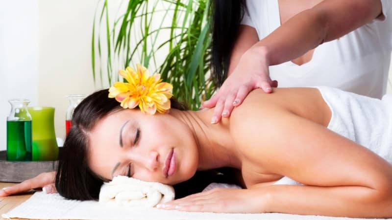 Eine Frau genießt eine entspannende Lomi Lomi Massage.