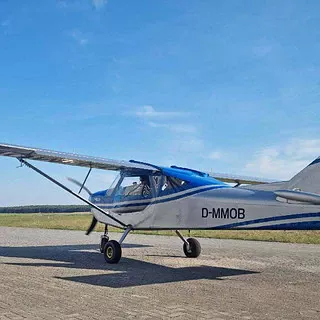 Ein kleines blaues Flugzeug auf einem Flugplatz