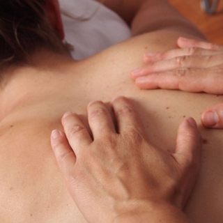 Hände massieren den Rücken bei der Ganzkörpermassage in Dresden