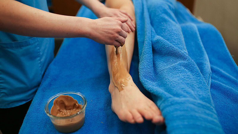 Frau cremt Frau das Bein bei der Massageanwendung süße Verführung in Dresden