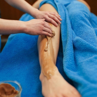 Frau cremt Frau das Bein bei der Massageanwendung süße Verführung in Dresden