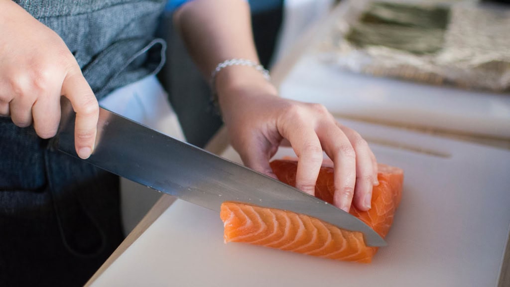 Sushi_Kochkurs_12.jpg Lachs wird mit einem Messer geschnitten