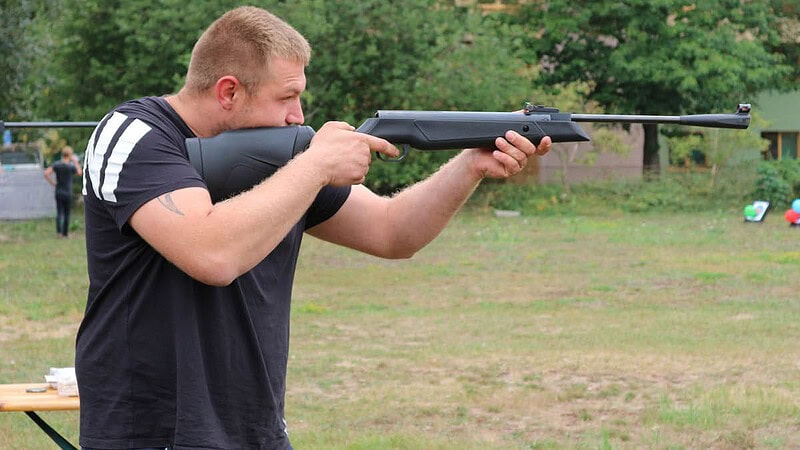 Mann beim Luftgewehr Schießen.