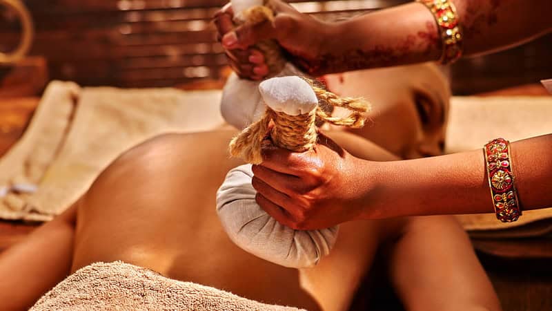 Eine Frau genießt die verschiedenen Techniken einer Ayurveda-Massage