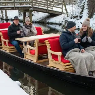Personen sitzen mit Glühwein auf dem Kahn im Spreewald
