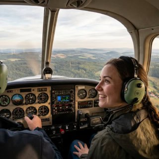 Eine Frau und ein Pilot im Cockpit während eines Rundflugs über das Erzgebirge