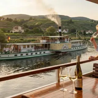 zwei Personen auf einem Dampfer mit Weingas in der Hand