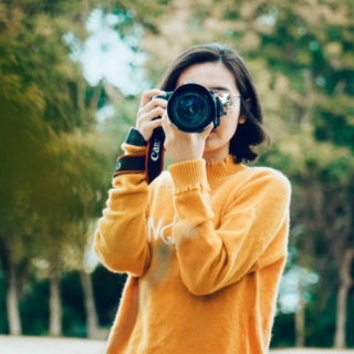 Eine Frau macht Fotos mit ihrer Kamera im Park