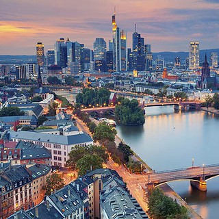 Luftaufnahme von Frankfurt am Main am Abend, Fluss und Brücke im Vordergrund