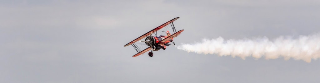 kunstflug-2 EIn rotes Flugzeug macht einen Kunstflug.