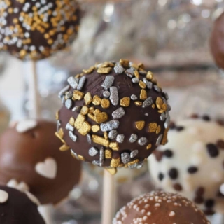 Pralinen mit Schokolade überzogen und mit essbaren Dekorationen verziert