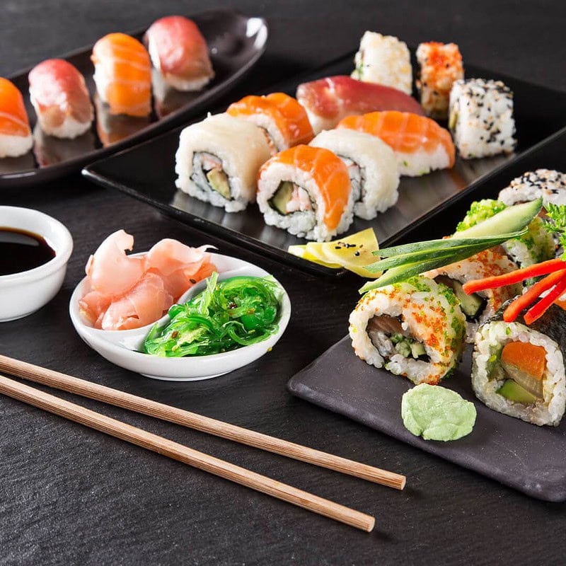 eine ästhetisch ansprechende Komposition aus Sushi, Stäbchen, Soßen und anderen Beilagen