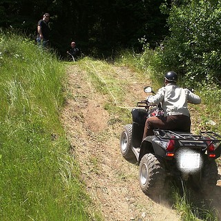 Ein Quadfahrer fährt einen steilen Hang hoch