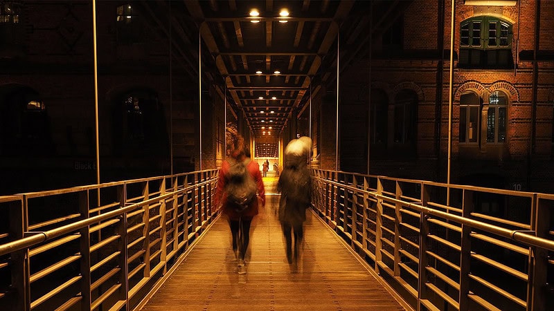 Brücke bei Nacht mit zwei Fußgängern in Langzeitbelichtung