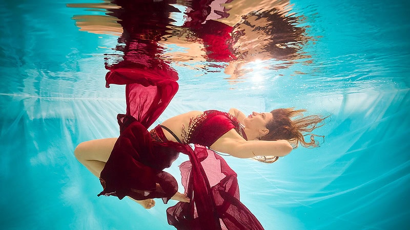 Eine Frau posiert schwebend beim Unterwasser Fotoshooting.