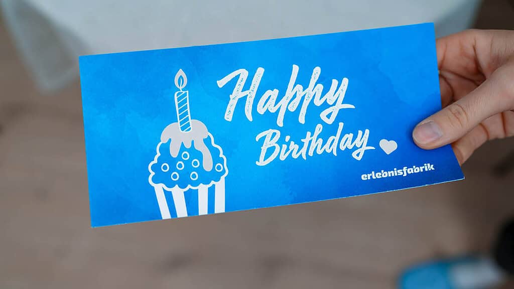 Ein Erlebnisgutschein mit Happy Birthday Aufschrift.