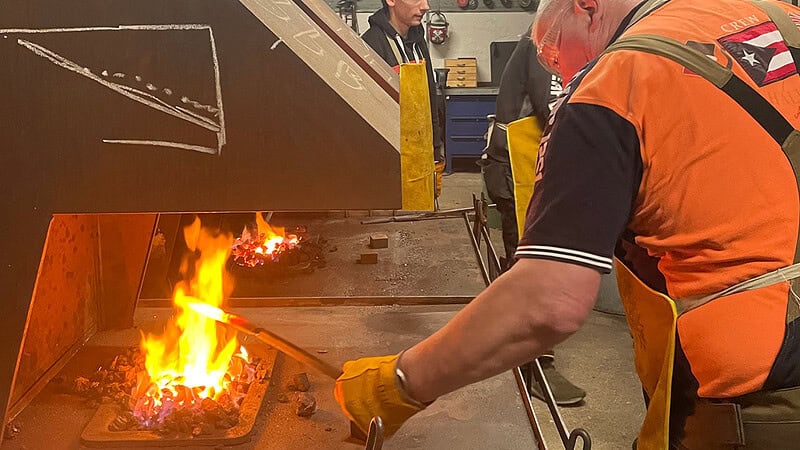 Mann arbeitet mit dem offenen Feuer