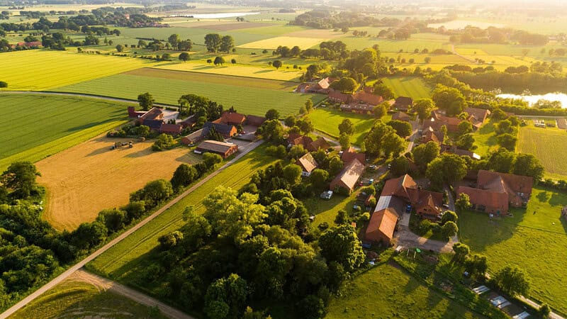 Aussicht auf Landschaft mit vereinzelten Häusern und Bäumen- Ballonfahrt- Landschaft