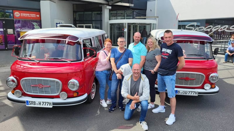 Eine Gruppe mit zwei Barkas vor dem Start der Stadtrundfahrt in Berlin.