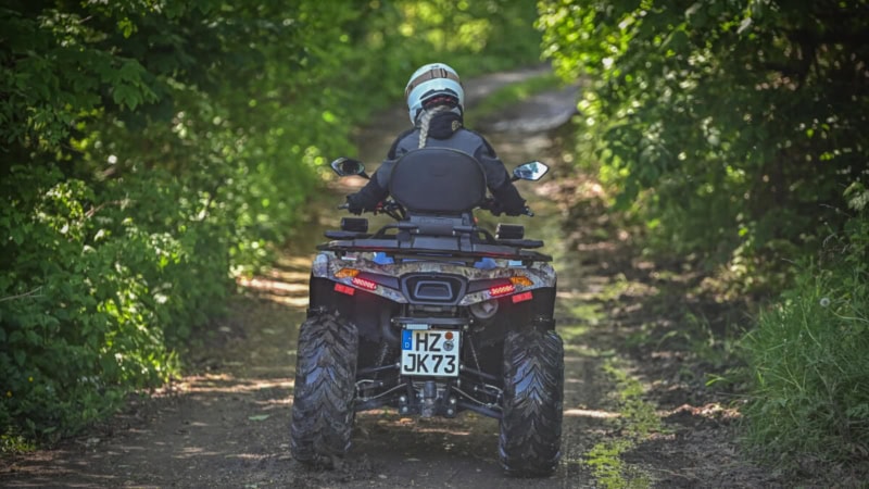 Quad Fahrerin auf einem Feldweg von hinten bei gemütlichen Ausflug.