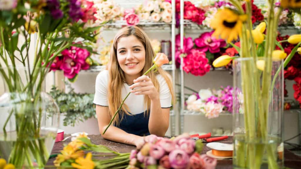 Eine Frau nimmt an einem Floristikkurs in einem Blumenladen teil.
