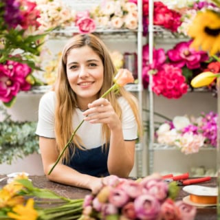 Eine Frau nimmt an einem Floristikkurs in einem Blumenladen teil.