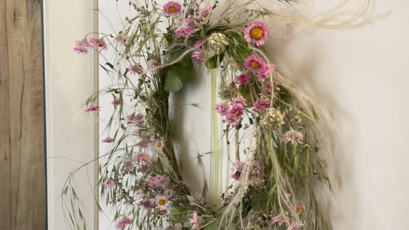 Ein Blumenkranz hängt auf einer Tür.
