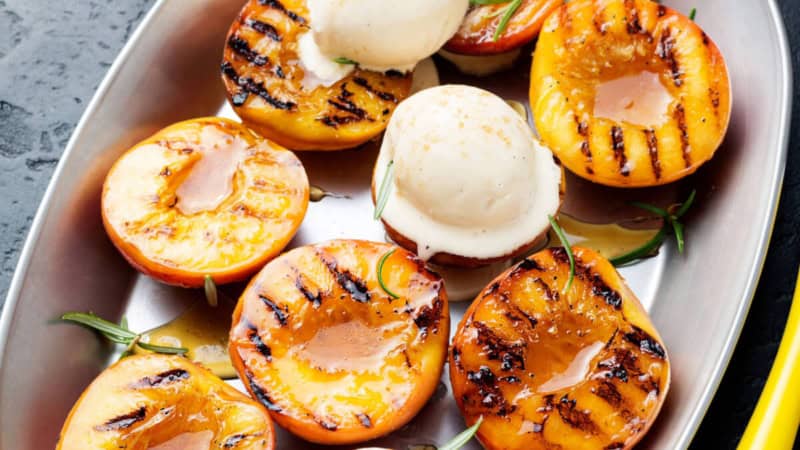 Gegrillte Aprikosen mit Eis auf einem Teller.