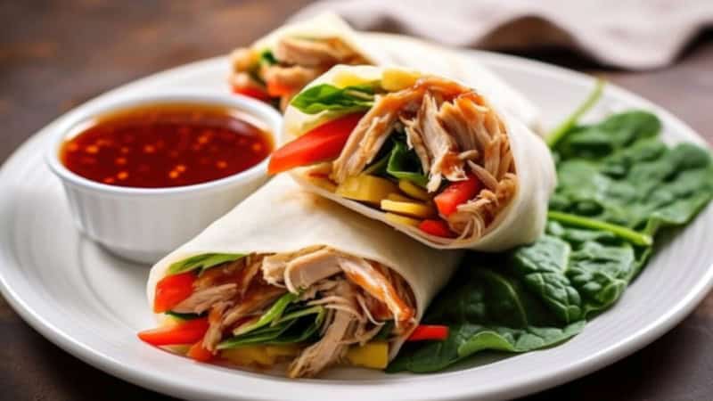 Pulled Pork Wraps auf einem Teller mit Soße und Gemüse.
