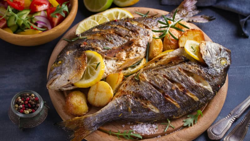 Fischgericht mit Gemüse und Zitronen.