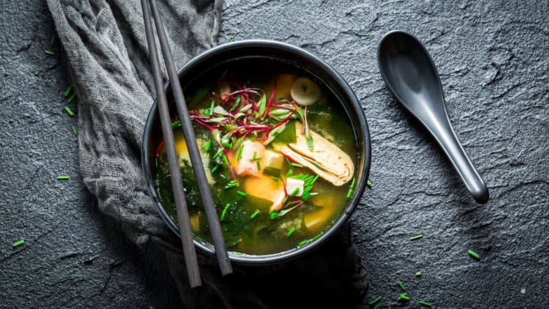Miso Suppe in einem Schüssel und mit kleinem traditionellen Löffel.