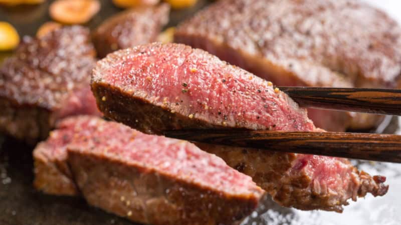Teppanyaki Fleisch wird mit Stäbchen gegessen.
