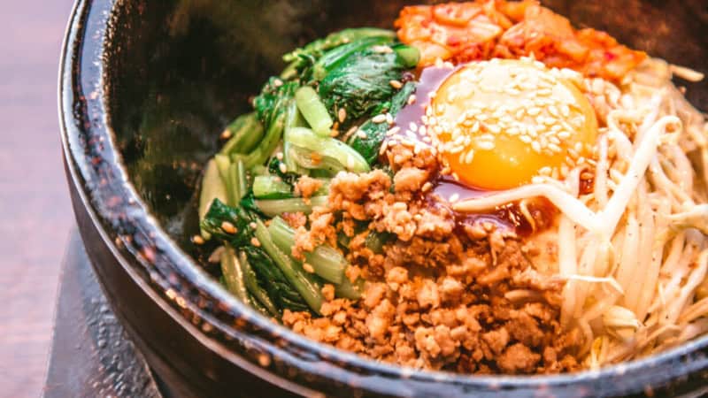 Koreanisches Gericht mit Ei, Pilzen und Gemüse in einem Schüssel.