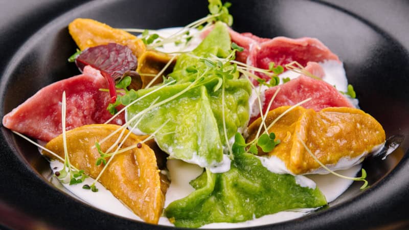 Selbstgemachte Pasta in Form von Teigtaschen mit Guacamole und Dip.