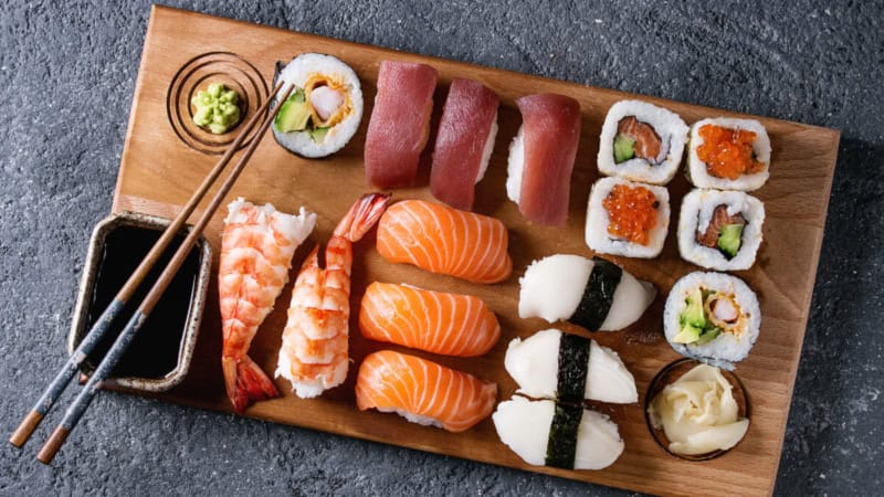 Ein Sushi Teller mit verschiedenen Sushi Sorten und Wasabi und Soja Soße.