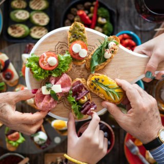 Die Teilnehmer eines Tapas-Kochkurses genießen gemeinsam das Essen.