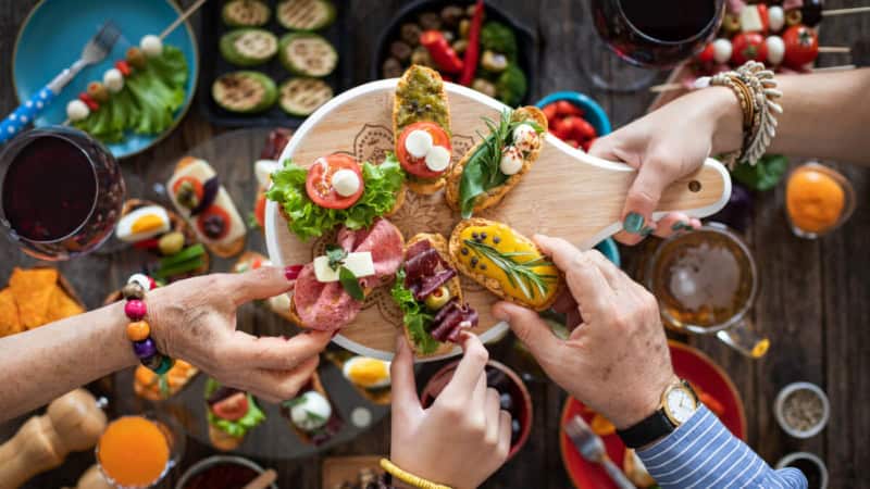 Die Teilnehmer eines Tapas-Kochkurses genießen gemeinsam das Essen.