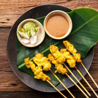 Thailändisches Gericht Muh Sate gelegt auf einem pflänzlichen Blatt.