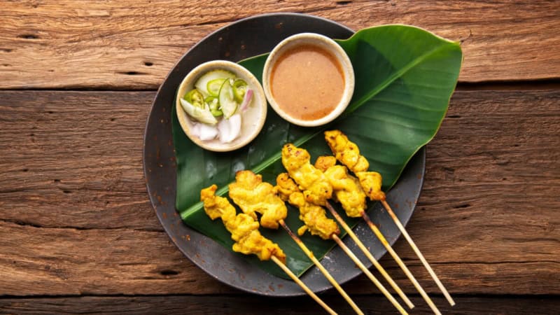 Thailändisches Gericht Muh Sate gelegt auf einem pflänzlichen Blatt.
