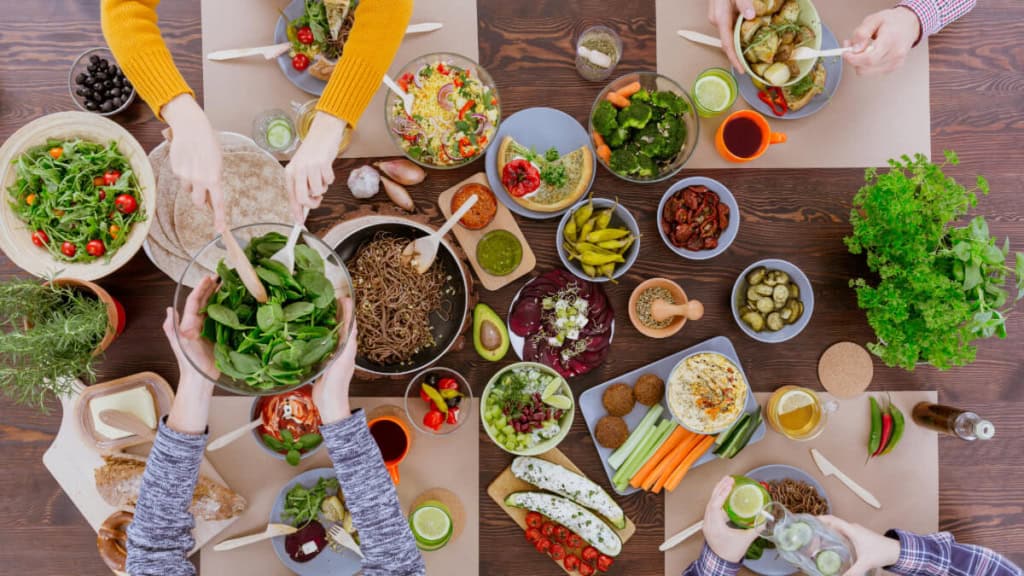 Die Teilnehmer eines vegetarischen Kochkurses bereiten gemeinsam das Essen zu.
