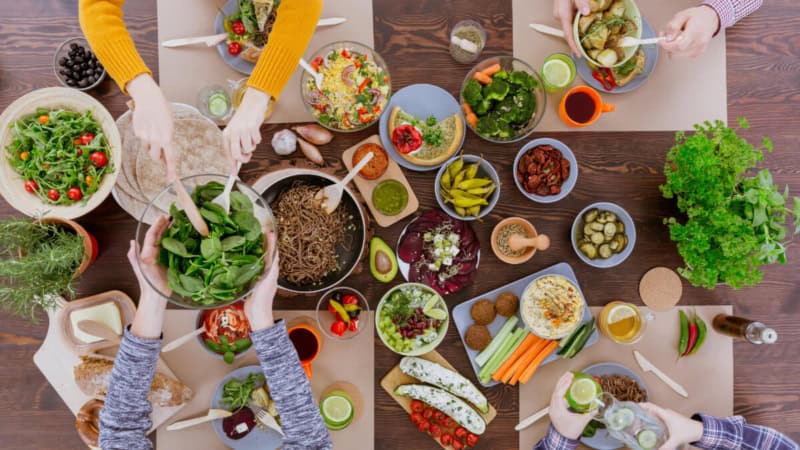 Die Teilnehmer eines vegetarischen Kochkurses bereiten gemeinsam das Essen zu.